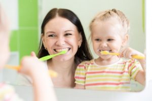 mom child brushing teeth
